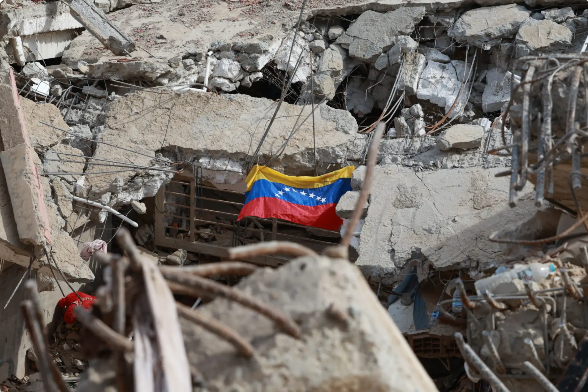 Venezuelan flag hanging among the rubble of a damaged building